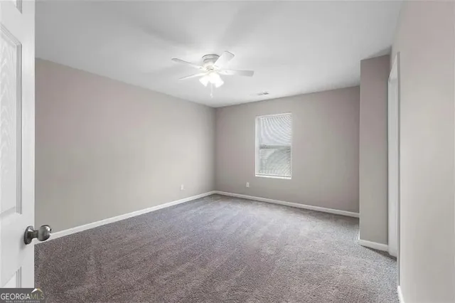 an empty room with fan and entrance