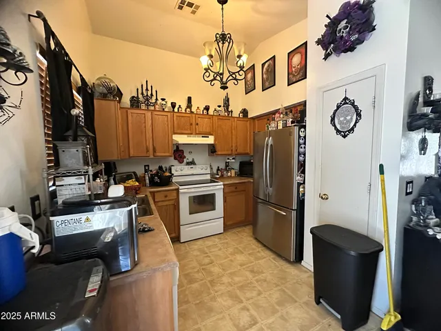 a kitchen with stainless steel appliances granite countertop a refrigerator a stove top oven a sink and dishwasher