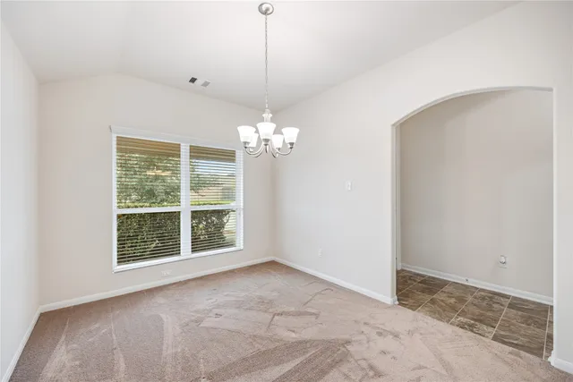 a living room with furniture kitchen view and a chandelier