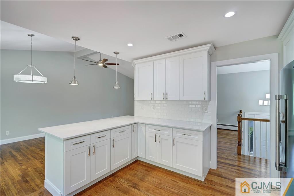 203 Riverbend Road Berkeley Heights, NJ 07922 - Photo 22 of 42 a kitchen with white cabinets and wooden floor