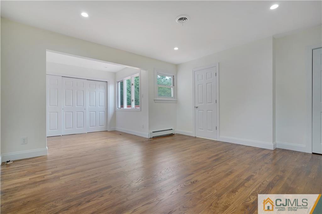 203 Riverbend Road Berkeley Heights, NJ 07922 - Photo 24 of 42 an empty room with wooden floor and windows
