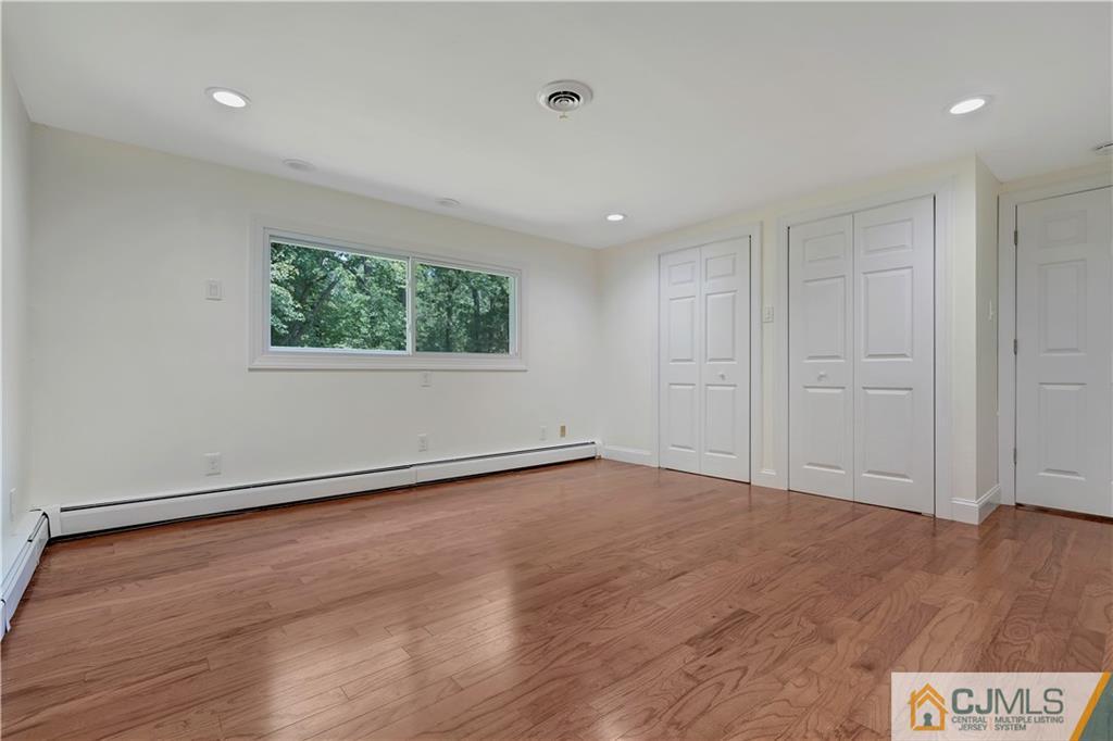 203 Riverbend Road Berkeley Heights, NJ 07922 - Photo 9 of 42 a view of an empty room with wooden floor and a window