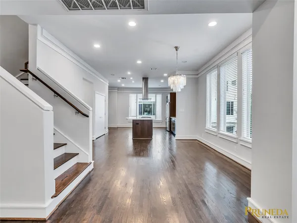 a view of a big room with wooden floor and windows
