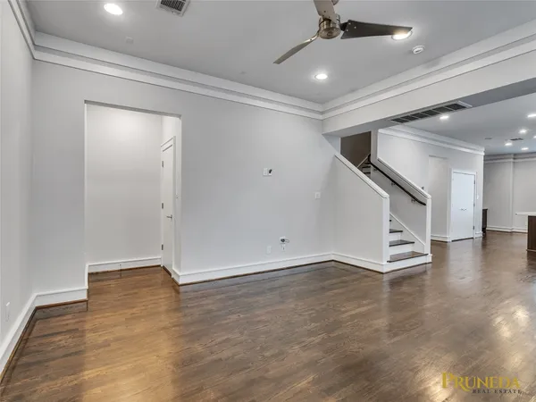 an empty room with wooden floor and staircase