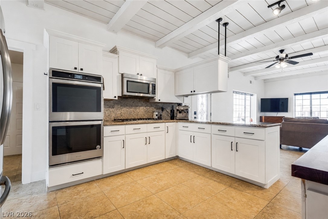 524 Swallow Cove Boulder City, NV 89005 - Photo 14 of 58 Brightly illuminated, this open kitchen boasts granite countertops, tile flooring, and exposed beam ceilings.
