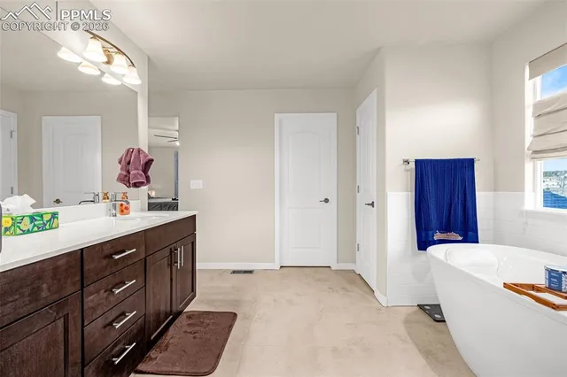 a spacious bathroom with a tub double sink and mirror