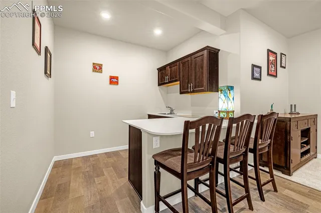 a kitchen with stainless steel appliances a dining table chairs and a refrigerator