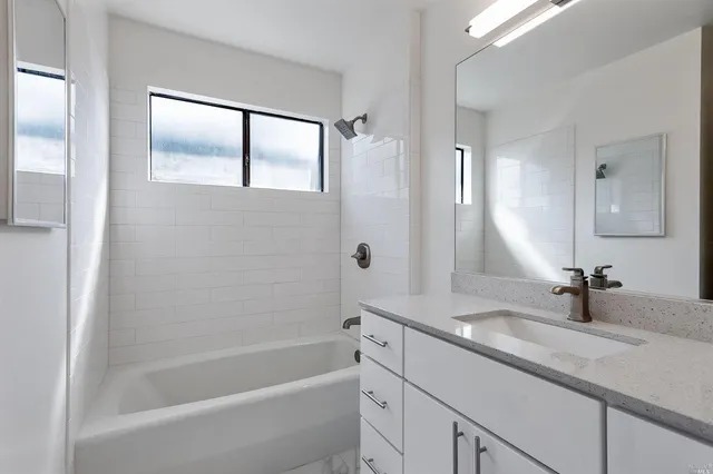 a bathroom with a tub sink and mirror