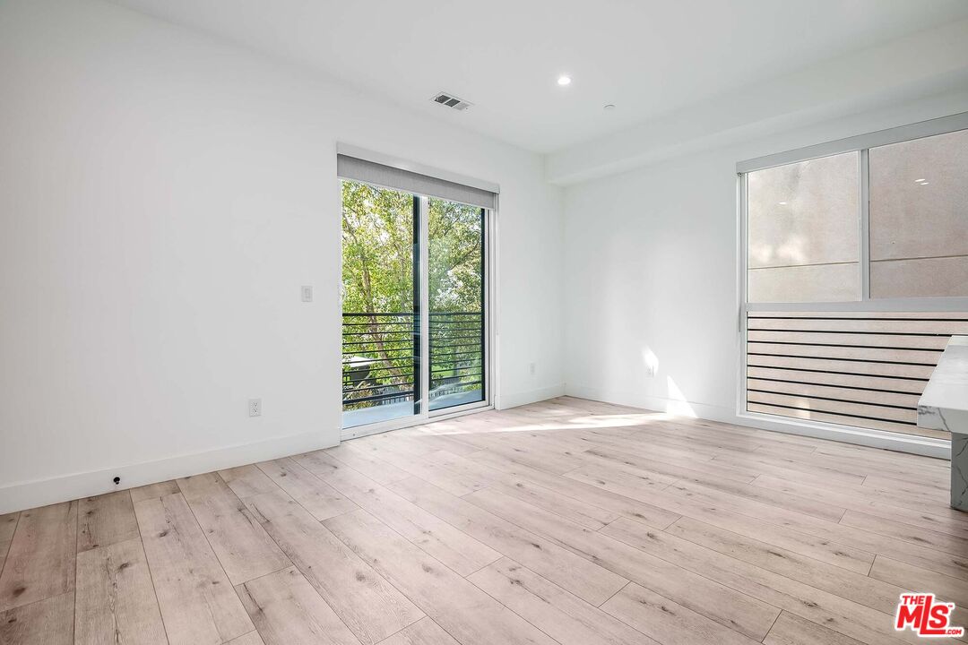 15330 Weddington Street Sherman Oaks, CA 91411 - Photo 11 of 30 a view of an empty room with wooden floor and a window