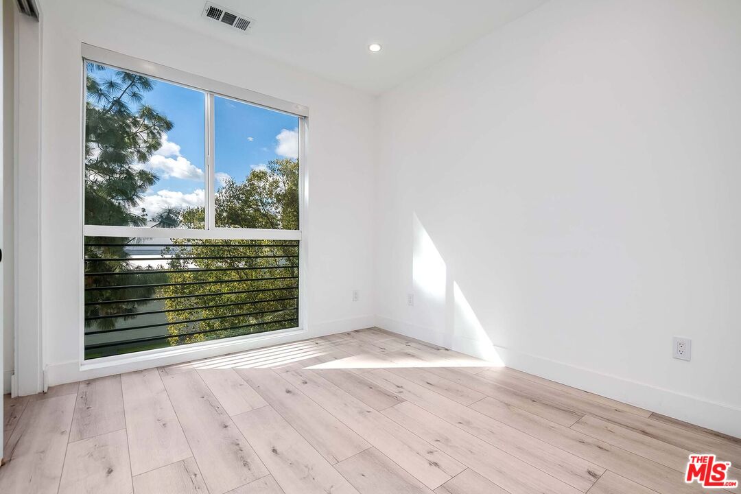 15330 Weddington Street Sherman Oaks, CA 91411 - Photo 17 of 30 an empty room with wooden floor and windows