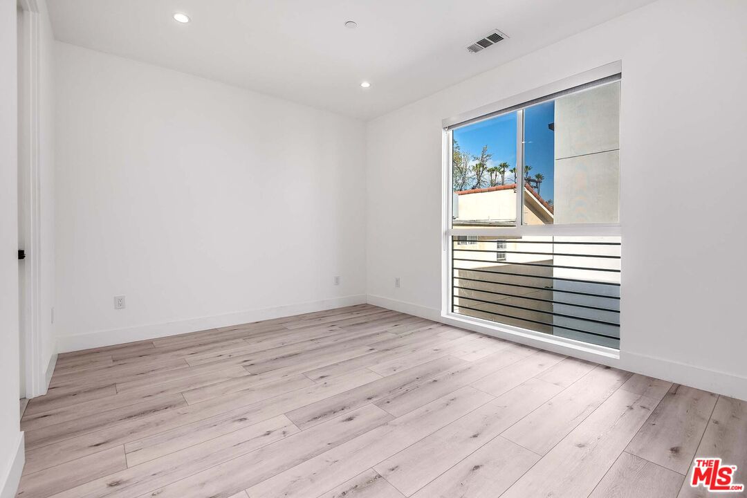 15330 Weddington Street Sherman Oaks, CA 91411 - Photo 21 of 30 a view of an empty room with wooden floor and a window