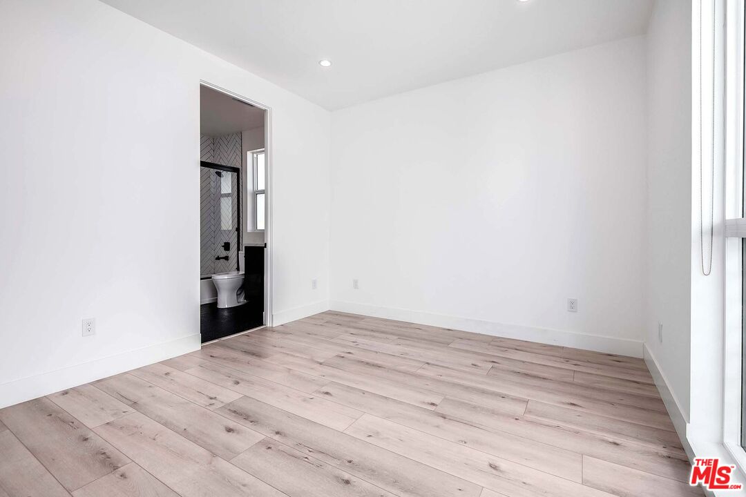 15330 Weddington Street Sherman Oaks, CA 91411 - Photo 22 of 30 a view of an empty room with wooden floor and a window