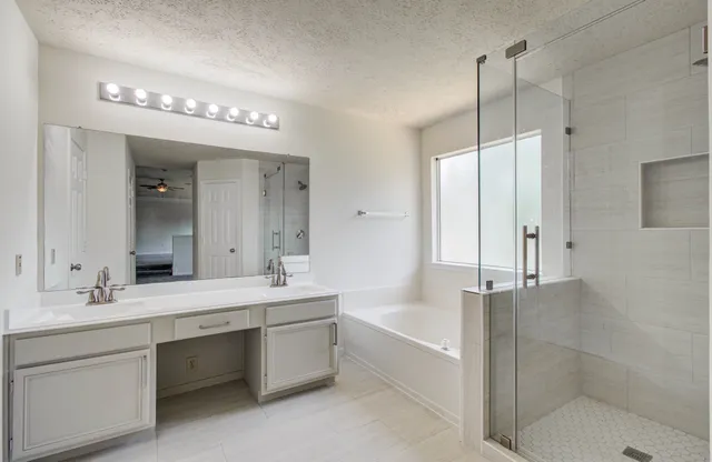 a bathroom with a tub sink shower and mirror