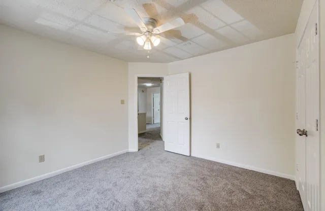 an empty room with a ceiling fan and a window