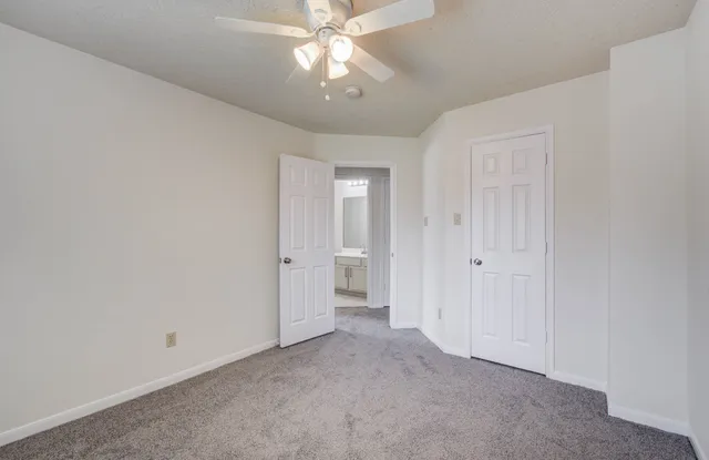 a view of an empty room and a ceiling fan window