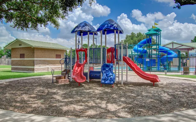 a view of a park with slide and potted plants