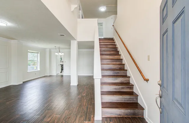 a view of an entryway with wooden floor and stairs