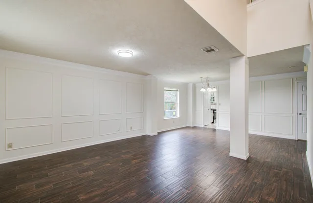 a view of an empty room with wooden floor