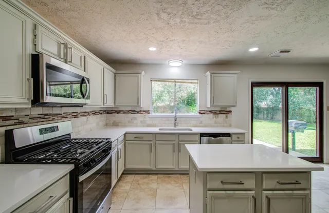 a kitchen with a sink stove and cabinets
