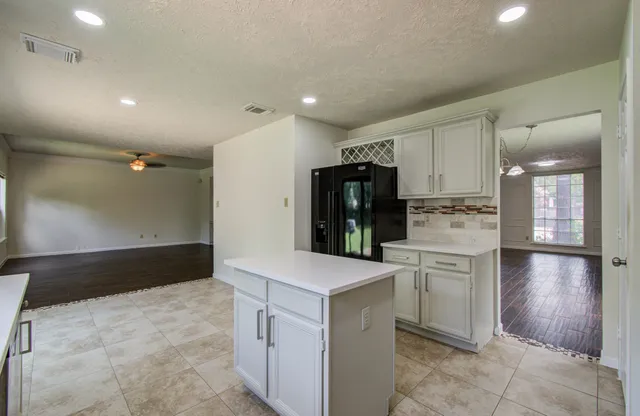 a kitchen with refrigerator and cabinets