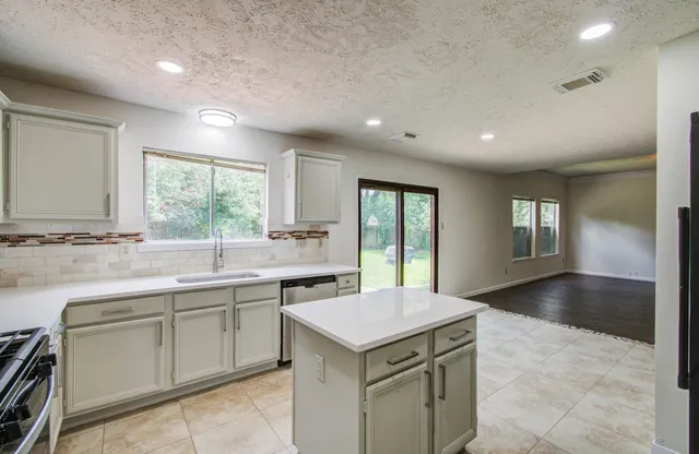 a kitchen with a stove sink and cabinets