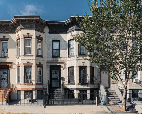 a front view of a residential apartment building with a yard