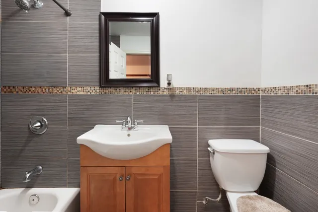 a bathroom with a toilet a sink and mirror