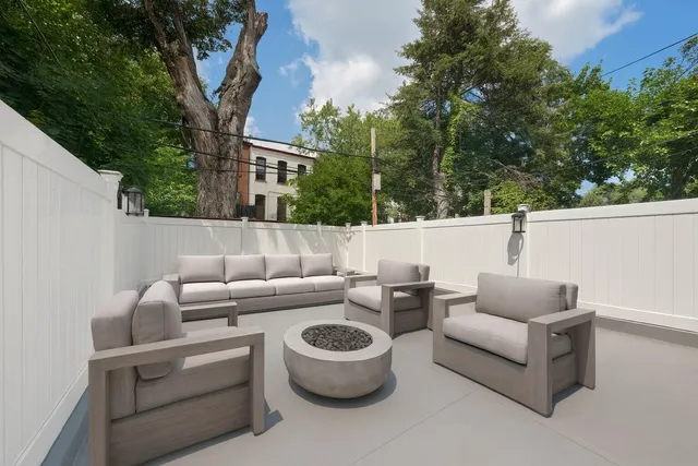 a roof deck with couches and potted plants