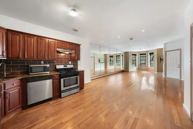 a kitchen with stainless steel appliances granite countertop a stove a sink and a microwave