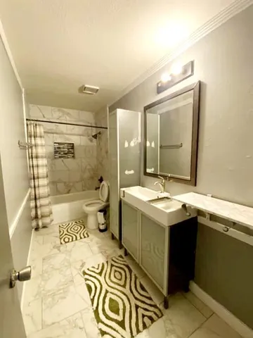 a bathroom with a sink and mirror with bathtub
