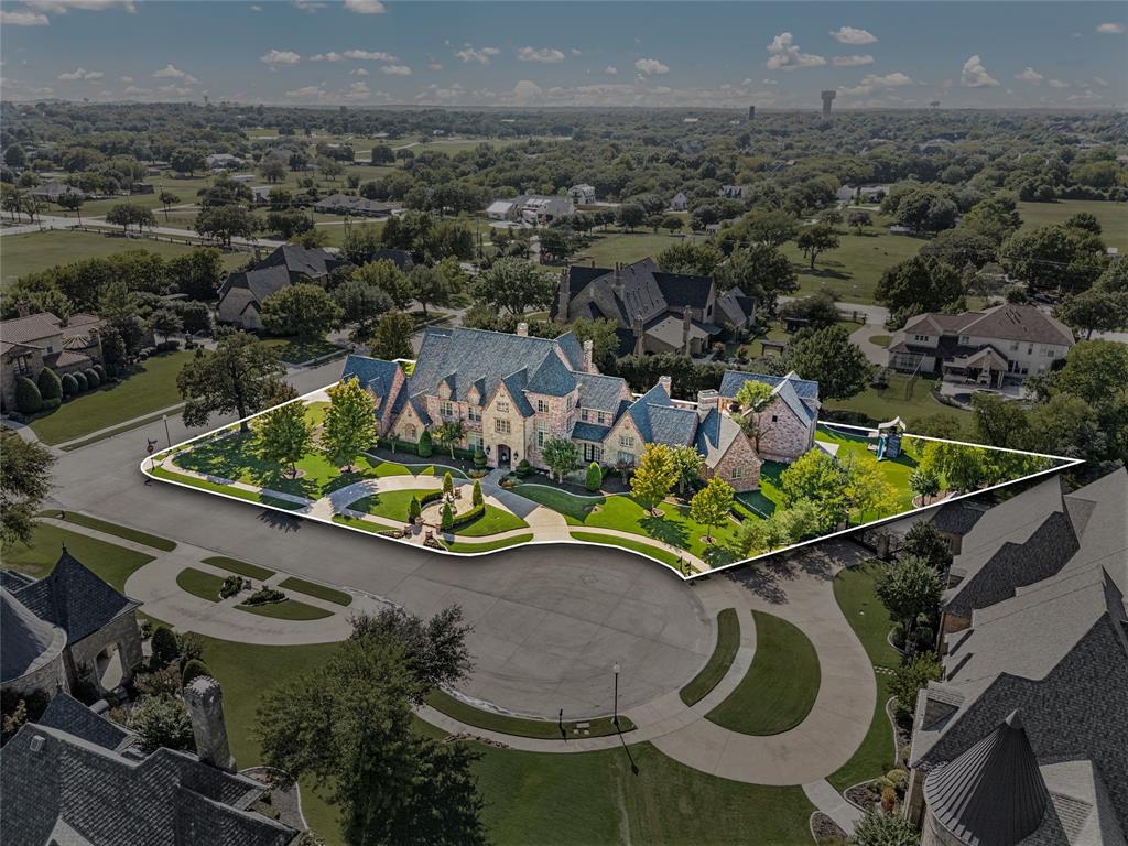 6900 Rockingham Court Colleyville, TX 76034 - Photo 1 of 40 Gated, Grand, Private, updated estate featuring a multi-gabled roofline, stone and brick facade, circular driveway, fountain courtyard, perfect for entertaining and grand living with it's sports pool, spa, and baby pool, game room, theater room, play room, fitness studio, craft room, 4 living areas, 3 dining areas, soaring ceilings, offices, detached 2-Story Guest House, 4-Car Gated Garage, New Roof in 2024, mature landscaping, outdoor kitchen, 5 covered balconies and patios, artificial turfed playground and putting green.