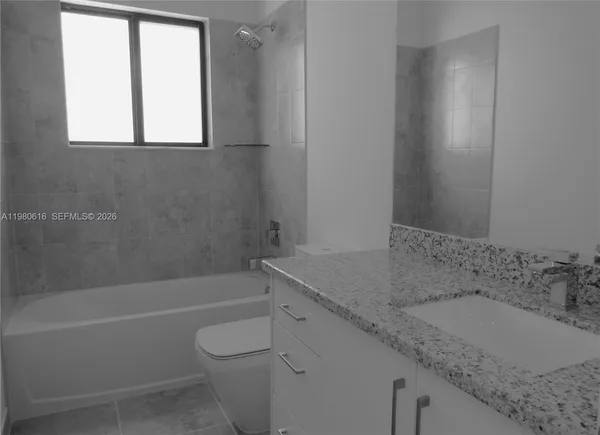a bathroom with a granite countertop sink toilet and bathtub