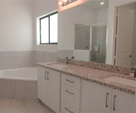 a bathroom with a granite countertop sink a mirror and a bathtub