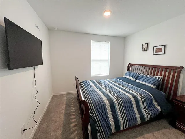 a bedroom with a bed and a flat screen tv