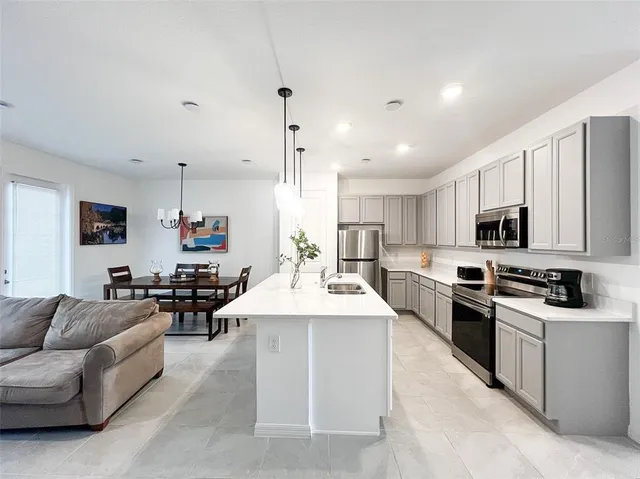 a large kitchen with stainless steel appliances lots of white cabinets