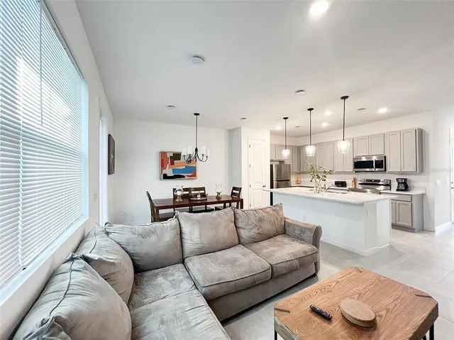 a living room with furniture and kitchen view
