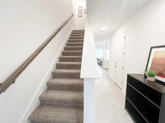 a view of a hallway to room with stairs and furniture