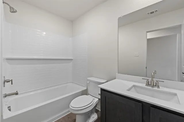 a bathroom with a granite countertop sink toilet and bathtub