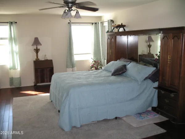 a bedroom with a bed and a mirror on the dresser