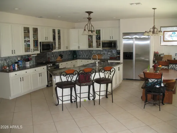 a kitchen with granite countertop a sink dining table and chairs