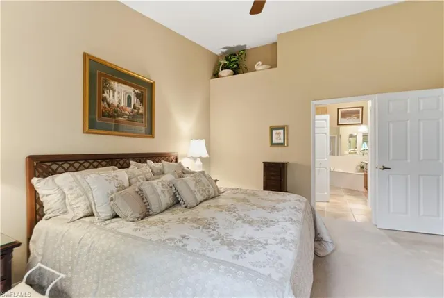a bedroom with a large bed and a chandelier