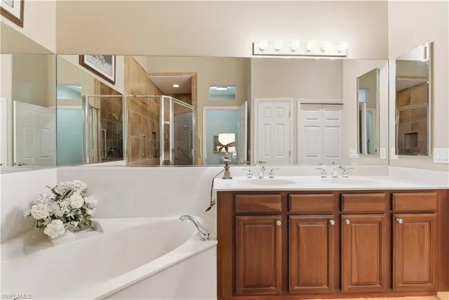 a bathroom with a tub sink and mirror