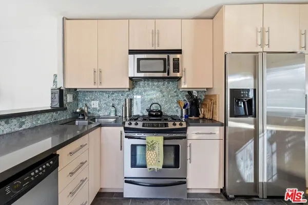 a kitchen with cabinets stainless steel appliances and a counter space