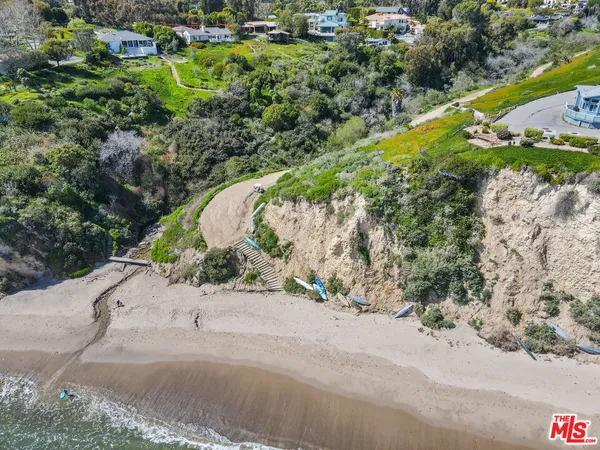 an aerial view of a house with a yard and lake