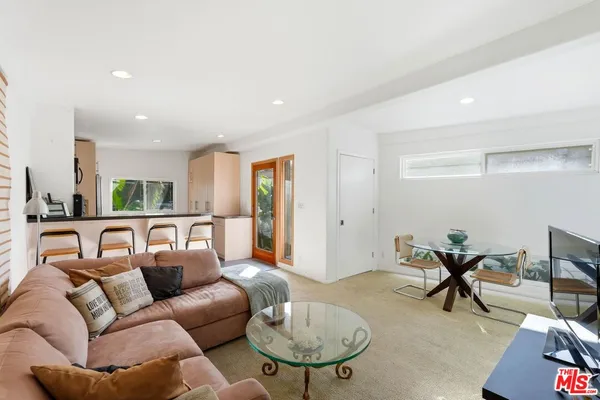 a living room with furniture a table and a potted plant