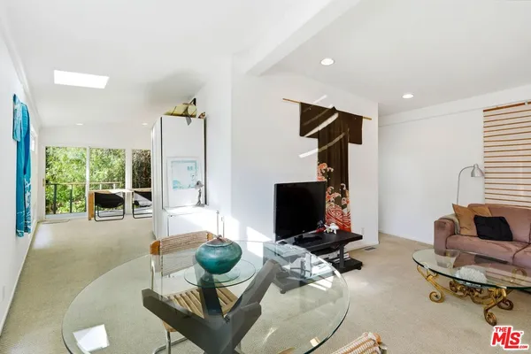 a living room with furniture gym equipment and a large window