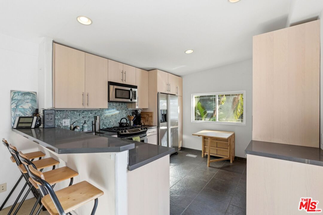 67 Paradise Cove Road Malibu, CA 90265 - Photo 9 of 45 a kitchen with a dining table chairs and refrigerator