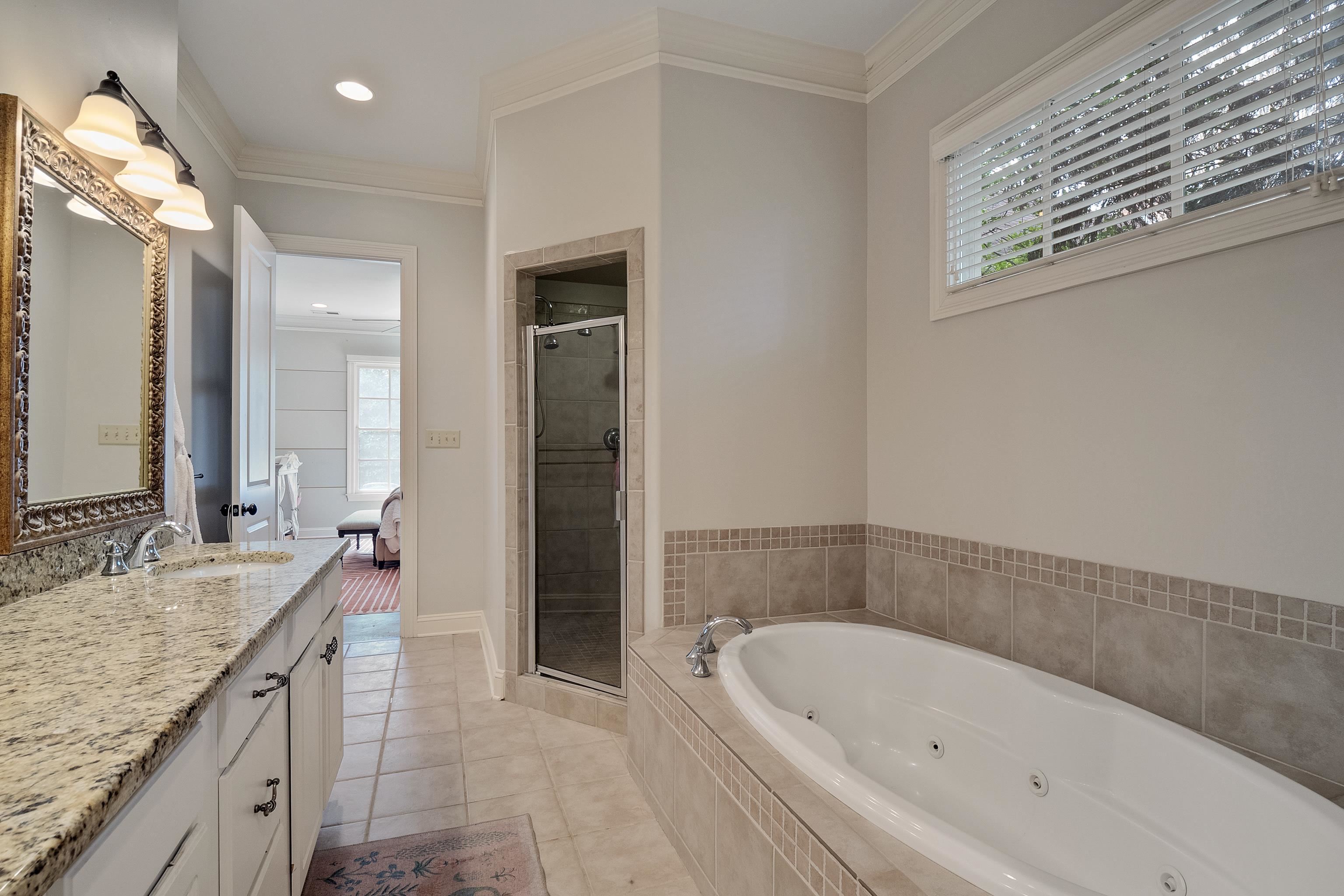 187 Ridgefield Road Memphis, TN 38111 - Photo 19 of 34 a bathroom with a granite countertop tub a sink and a large mirror
