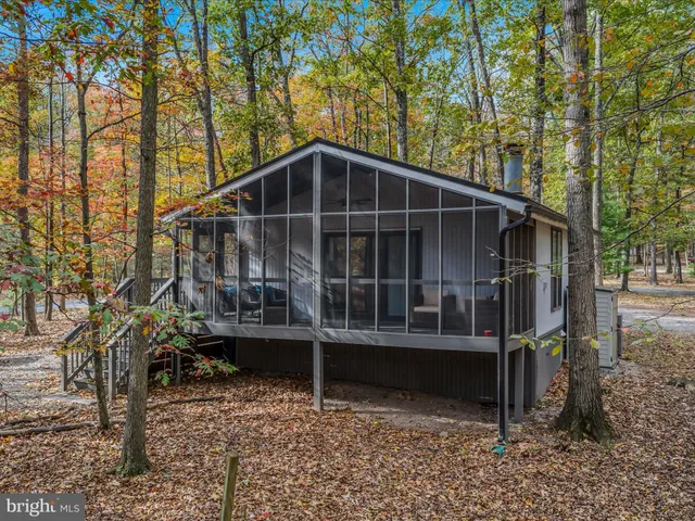 a view of a wooden house with a large window and wooden fence
