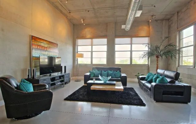 a living room with furniture flat screen tv and a large window